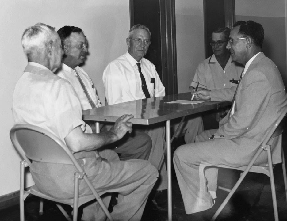 Founding members J.M. King Sr., J.C. Brooks, B.T. Graham and Johnnie Morgan gather around a table with Pastor R.C. Hester for a monthly deacons' meeting at Greenwood Baptist Church in August of 1959.