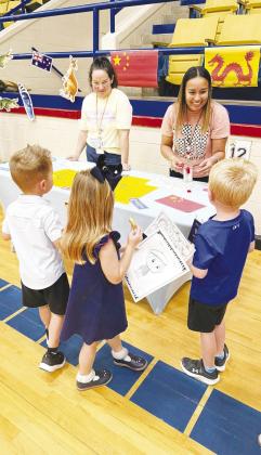 Incoming kindergarten students get their passports stamped at the China booth during Greenwood Elementary’s “Rangers Take Flight” orientation.