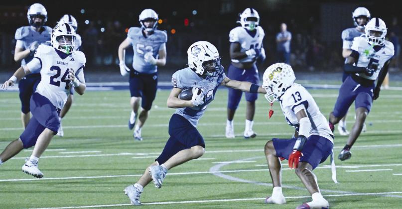 Greenwood’s Tripp Martin (22) skirts past a Legacy’s Da’Kendrick Jones for a 74-yard touchdown run Friday night during Homecoming action.
