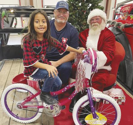Santa Claus and the Greenwood VFD are ready for another bike raffle. This lucky little lady was last years winner.