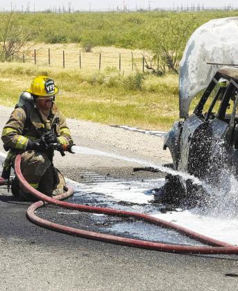 A Greenwood Volunteer Fire Department firefighter extinguishes a car fire. The department marks 42 years of service this year.