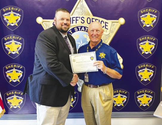 Greenwood graduate Jace Dorner, left, shakes hands with Midland County Sheriff David Criner after being promoted to sergeant in the Midland County Sheriff's Office Criminal Investigations Division.