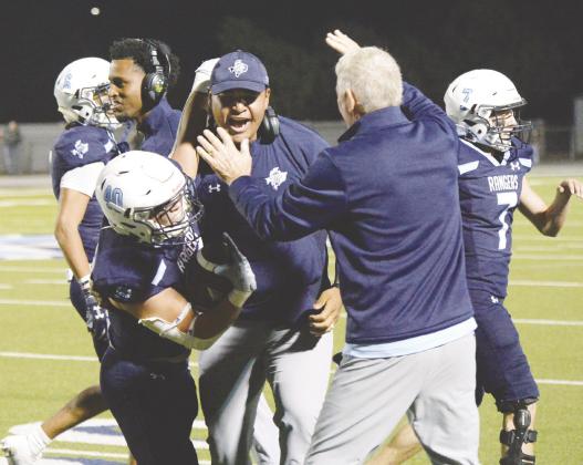 Greenwood’s Lee Bingham celebrates with his coaches after recovering a fumble that allowed the offense to run out the clock and beat No. 4 Seminole last Friday.