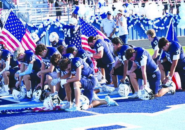 Faith, Country and Football — The Greenwood football team gathers in the end zone with American flags for a pregame prayer before Friday night’s season opener against Jim Ned. The Rangers carried that unity and purpose onto the field, opening the season with a 39-12 victory.