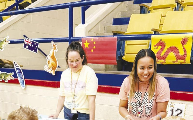 Incoming kindergarten students get their passports stamped at the China booth during Greenwood Elementary’s “Rangers Take Flight” orientation.