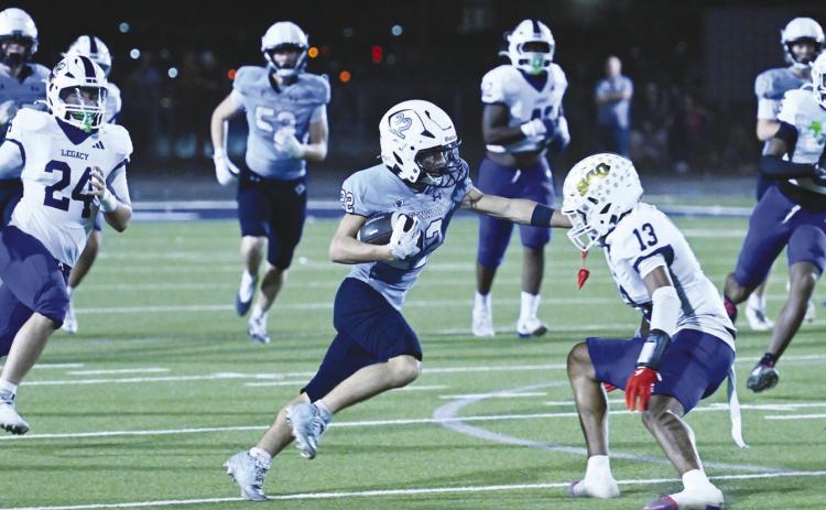 Greenwood’s Tripp Martin (22) skirts past a Legacy’s Da’Kendrick Jones for a 74-yard touchdown run Friday night during Homecoming action.