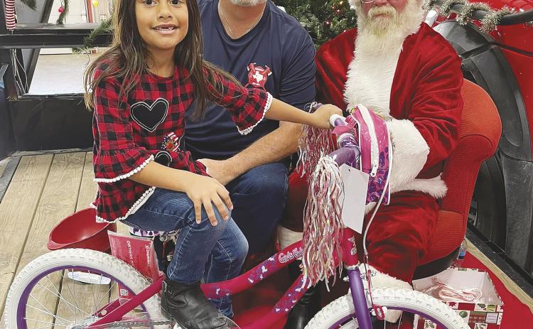 Santa Claus and the Greenwood VFD are ready for another bike raffle. This lucky little lady was last years winner.