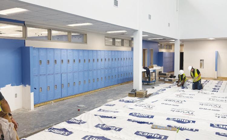 Two construction workers inside one of Greenwood ISD’s new campuses as crews continue preparing the buildings for the start of the 2026-27 school year in August.