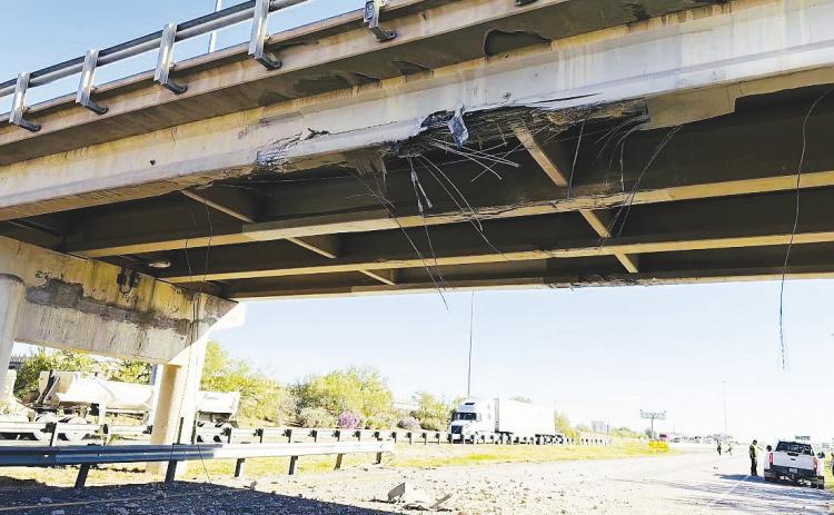 Chunks of concrete and other damage are visible underneath the Loop 250 overpass at I- 20 Tuesday after a commercial vehicle hauling a forklift struck the bridge. Pieces of the damaged bridge were left hanging above the roadway.