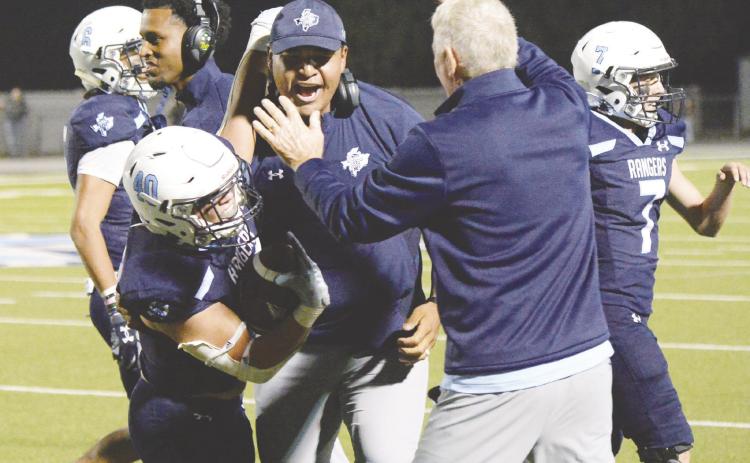 Greenwood’s Lee Bingham celebrates with his coaches after recovering a fumble that allowed the offense to run out the clock and beat No. 4 Seminole last Friday.